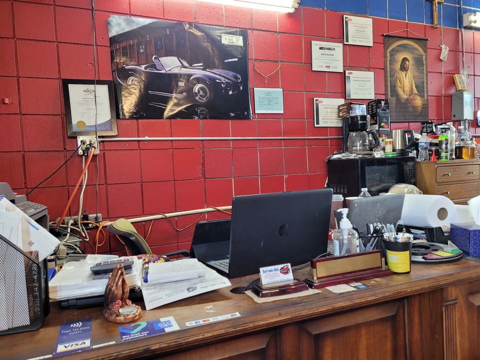 The front desk inside Ray's Auto Clinic with a classic car print on the wall
