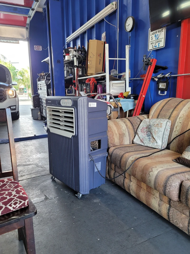The waiting area inside the shop with a couch and a swamp cooler